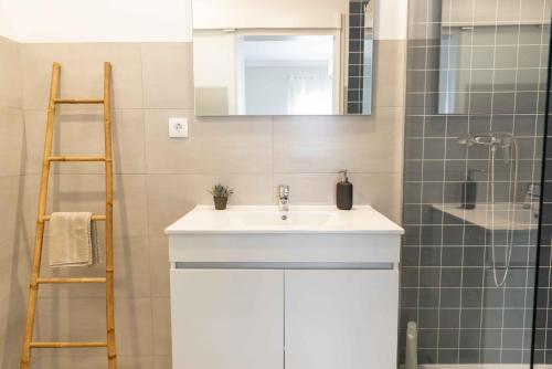 a bathroom with a white sink and a mirror at Olive House in Fátima