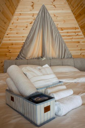 a bed with a pile of towels on it at Lumina Cottage in Gudauri