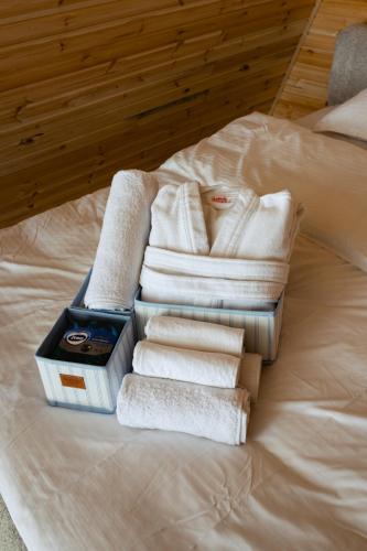 a pile of towels and towels on a bed at Lumina Cottage in Gudauri