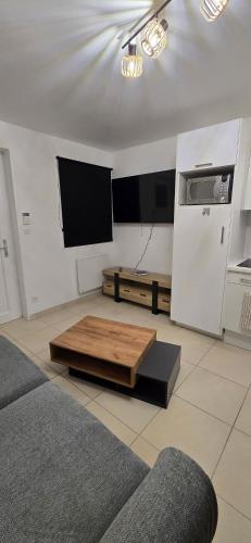 a living room with a tv and a coffee table at Studio Albert 1er in Oye-Plage