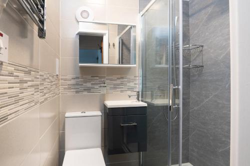 a bathroom with a toilet and a glass shower at Tŷ Gwyn Bach, Conwy in Conwy