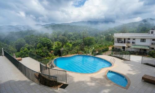 a swimming pool on a balcony with a view of a mountain at Vythiri Palace Wayanad Pool Resort - Mist Climate & India's First Apple Infinity Pool in Vythiri