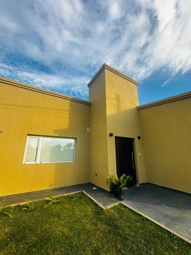 a yellow building with a window and a door at Los Agapanthus in General Belgrano
