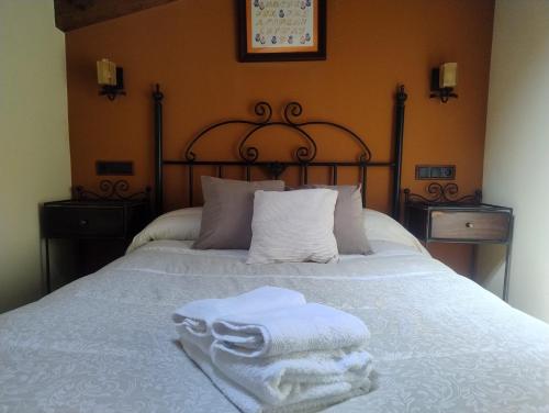 a bed with two towels sitting on top of it at Casa rural Angelita in Cangas de Onís