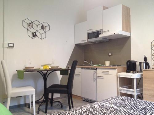 een kleine keuken met een tafel en stoelen in een kamer bij Decorialab Apartments in Bologna
