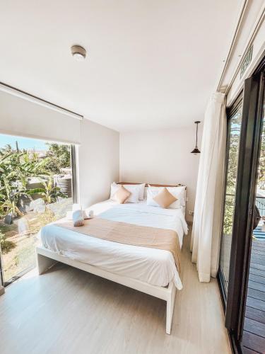 a bedroom with a large bed and a large window at OBOĒ Gardenstē in Pereybere