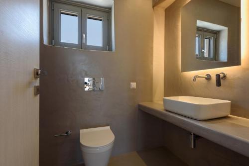 a bathroom with a sink and a toilet and a mirror at Aegean Gem Villa in Mármara