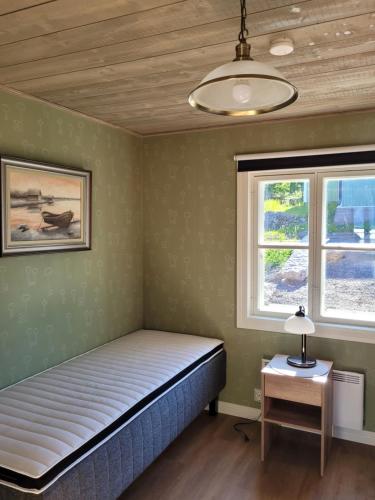 a bedroom with a bed and two windows at Majoitus Merihelmi in Kristinestad