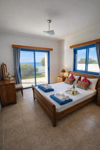 a bedroom with a large bed with a view of the ocean at Livia - Vikles Villas in Pomos