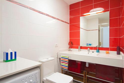 een badkamer met een wastafel, een toilet en een spiegel bij Playa Flamingo B in Playa Blanca