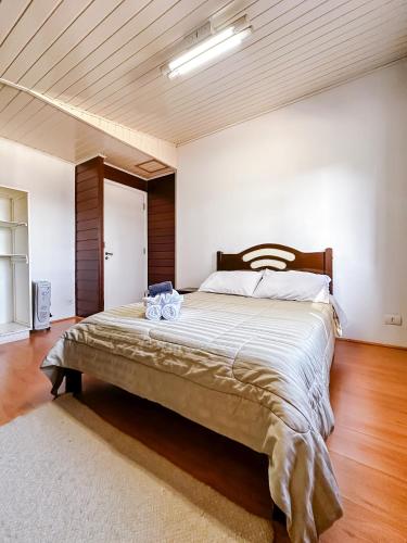 a bedroom with a large bed with a wooden headboard at Pousada do Vento in Campos do Jordão
