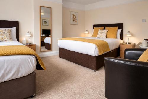 a hotel room with two beds and a mirror at Hampton Lodge En-Suite Rooms with Free Parking in Stratford-upon-Avon