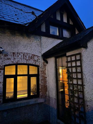 a building with two windows with lights in it at Kilpedder cottage in Kilpedder