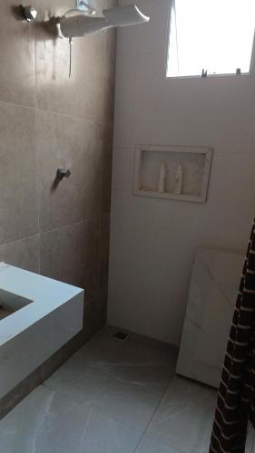 a bathroom with a shower and a sink and a window at Edicula para temporada in Piracicaba