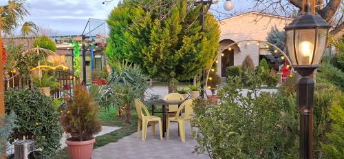 a garden with a table and chairs and plants at Green Land in Tbilisi City