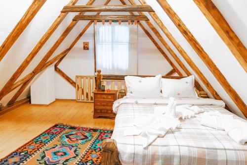 ein Schlafzimmer mit einem Bett auf dem Dachboden in der Unterkunft Casa Grosu in Preluca