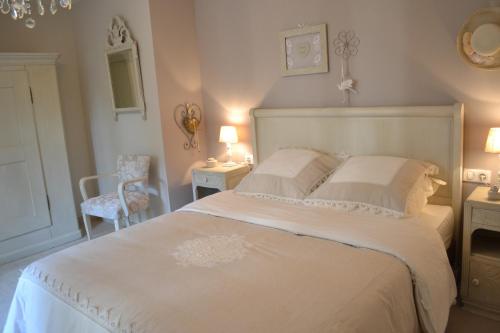 a bedroom with a white bed and a chair at Gîte La Cour Anglaise in Plobsheim