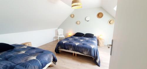 a bedroom with two beds in a attic at la petite roche in Lanildut
