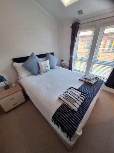 a bedroom with a large bed with towels on it at Bayview Luxury Lodge in Cockburnspath