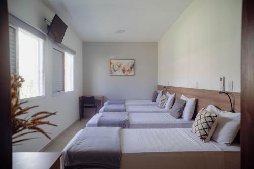 a bedroom with four beds in a room at Gran Carlo Hotel in Taubaté