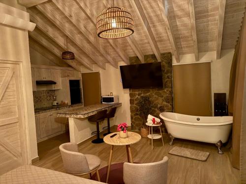 a bathroom with a tub and a kitchen with a tv at Cabañas San Antonio in Ezequiel Montes