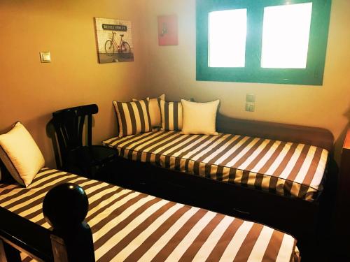 a room with two beds and a window at Villa Vravrona Tower & Suites in Markopoulo