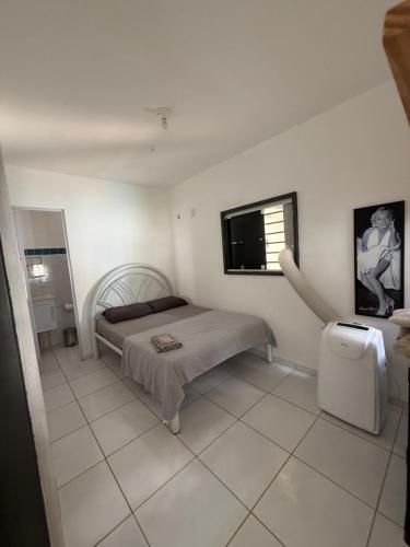 a bedroom with a bed and a flat screen tv at Conteiner House in Pipa
