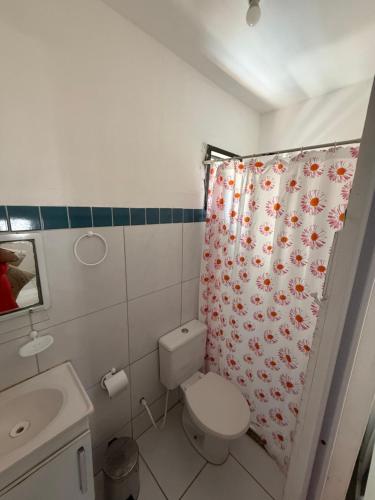 a bathroom with a toilet and a shower curtain at Conteiner House in Pipa