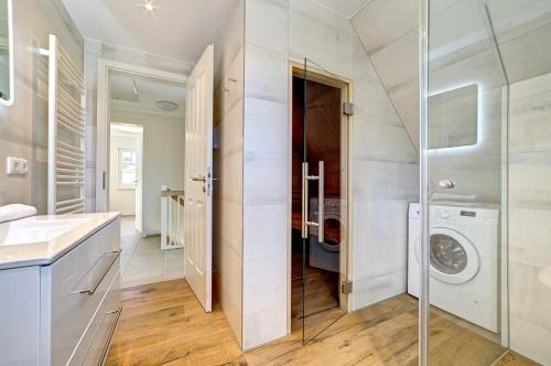 a bathroom with a washer and dryer in a house at Strandvej in Prerow
