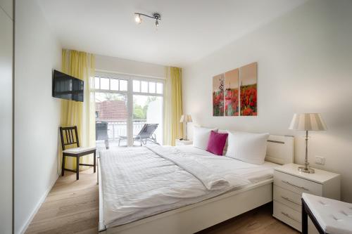 a bedroom with a large white bed with a window at Deichblick in Prerow