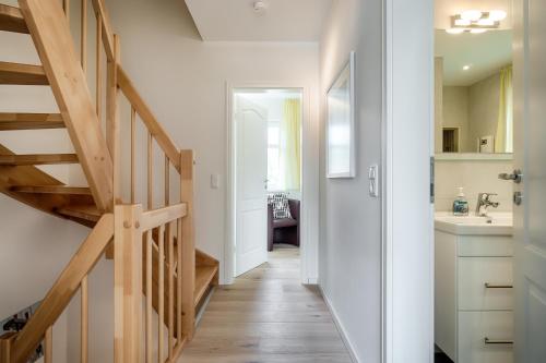 a hallway leading to a kitchen with wooden stairs at Deichblick in Prerow