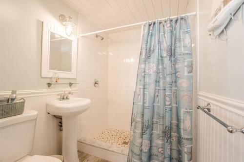 a bathroom with a shower curtain and a sink at Oceanfront Cottage - Steps from Short Sands Beach! in York