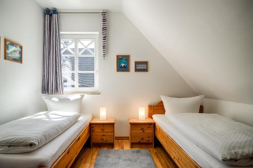 two twin beds in a room with a window at Min Leefste in Prerow