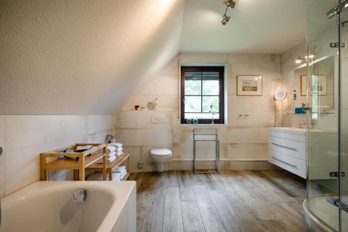 a bathroom with a tub and a toilet and a sink at Emma in Prerow