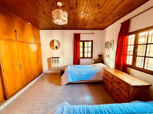 a bedroom with two beds and a wooden ceiling at Departamento céntrico in Esquel