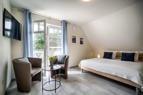 a bedroom with a bed and a table and chairs at Strandzeit in Prerow
