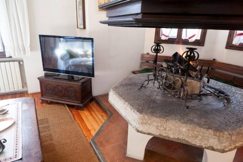 a living room with a tv and a table with a table at Casa Remo 1 in San Vito di Cadore