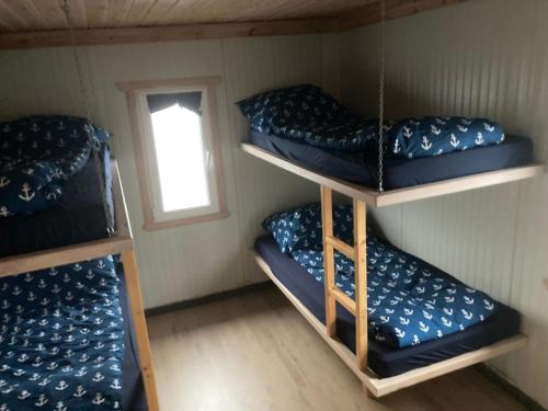 a room with three bunk beds and a window at Sætervika Floating home in Hosen