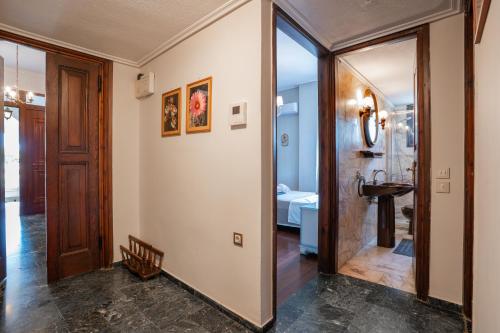 a hallway with a bathroom with a sink and a mirror at Gkr Luxury Villa in Aghia Marina