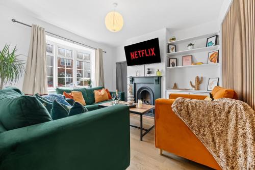 a living room with a green couch and a fireplace at Large Luxury 4 Bed Chic House Southampton Centre, Great for groups! Parking available, Sleeps 7- By Blue Puffin Stays in Southampton