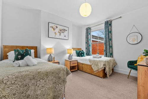 a bedroom with two beds and a window at Large Luxury 4 Bed Chic House Southampton Centre, Great for groups! Parking available, Sleeps 7- By Blue Puffin Stays in Southampton