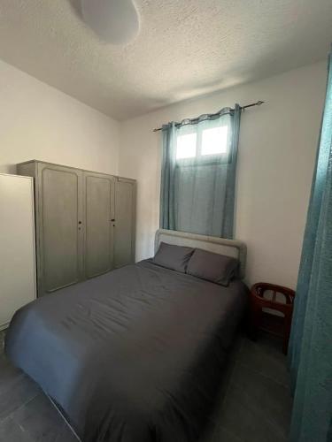 a bedroom with a bed and a window with blue curtains at Central Stone Living in Peyia