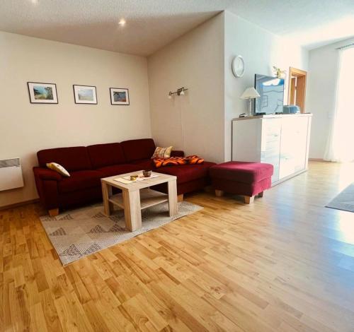 a living room with a red couch and a table at Ferienwohnung Westi in Thiessow