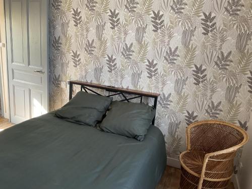 a bedroom with a bed with a chair and wallpaper at Maison 6 couchages in Le Monteil
