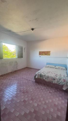 ein Schlafzimmer mit einem Bett und einem Fenster in der Unterkunft CasaMajorlândia in Aracati