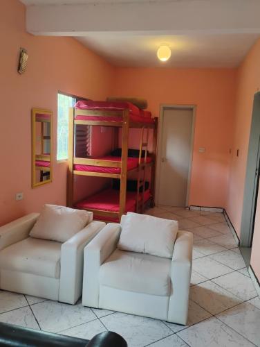 a living room with a couch and a bunk bed at lugar do descanso in Juqueri-Mirim