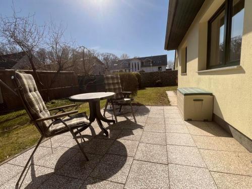 a patio with two chairs and a table and a table at Ferienwohnung Boston Terrier in Thiessow