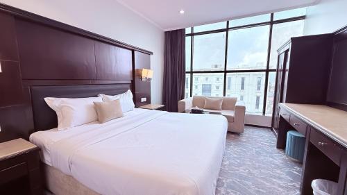 a hotel room with a large bed and a chair at اجنحة الطائف للشقق المخدومة - AL Taif Suites in Taif