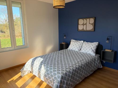 a bedroom with a bed with a blue wall at La Parenthèse in Sagy