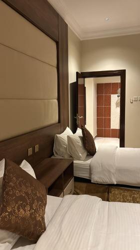 a hotel room with two beds and a mirror at سما الخليج للشقق المخدومة in Hafr Al-Batin